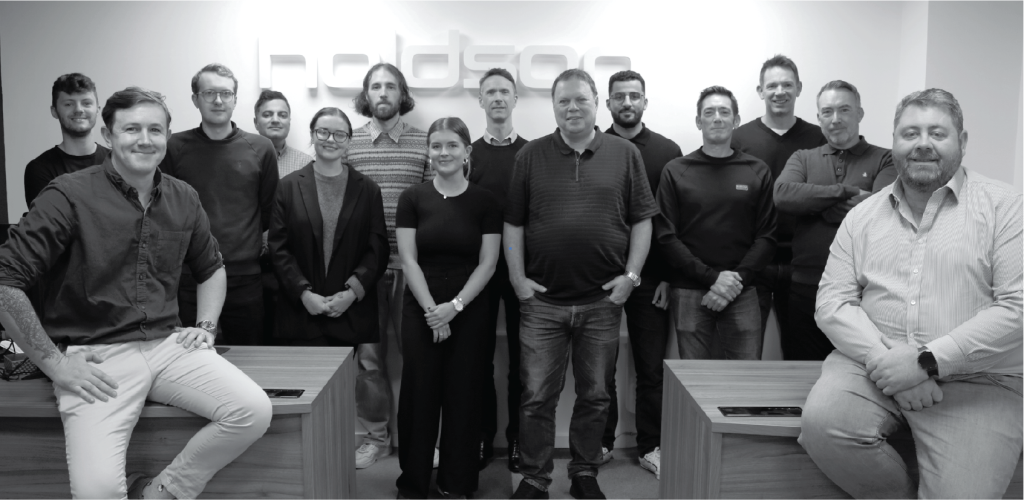 holdson team standing in front of Holdson logo